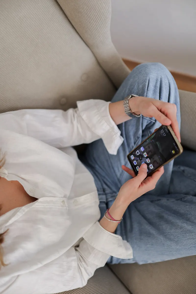 Žena opušteno drži pametni telefon